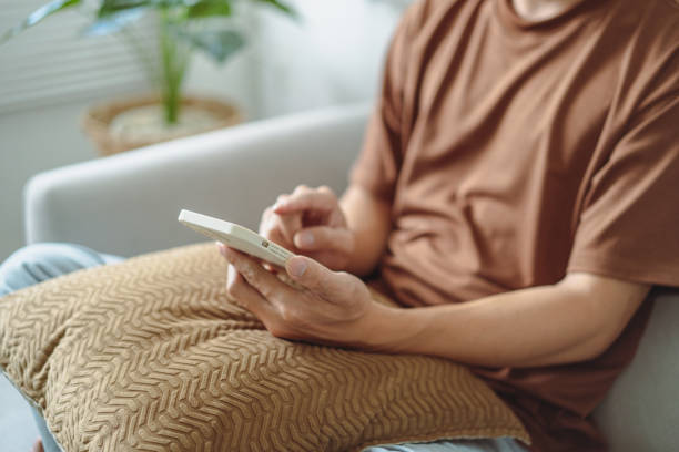 istock Relaxed young asian man using smart phone  spending time checking news social media 2157991826
