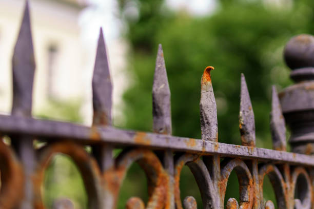 istock A row of sharp fence finials, one bent and rusted, highlighting decay amidst order 2157995705