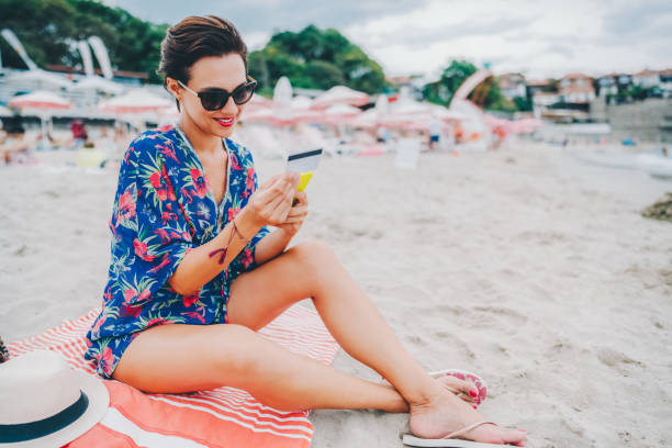 istock Woman using credit card at the beach 2157997338