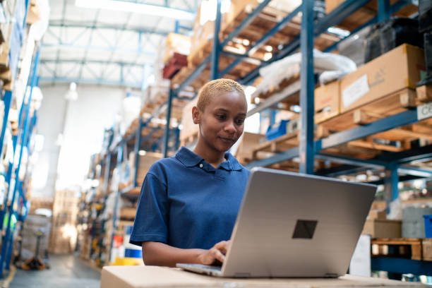 istock Young woman working on a laptop in warehouse 2157998520