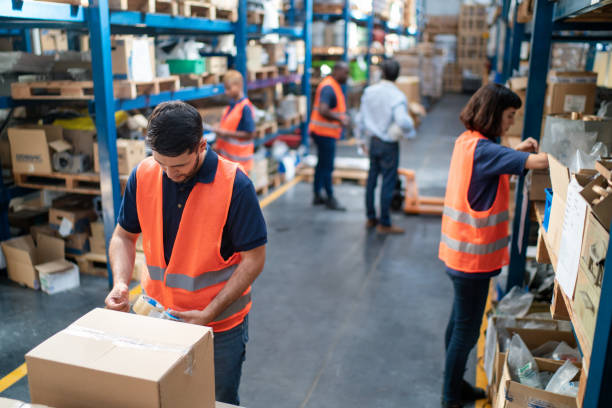 istock Worker sealing a cardboard box for delivery at distribution warehouse 2157998606
