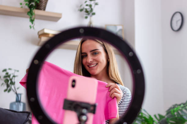 istock Influencer showing pink clothes through ring light during livestreaming from home 2158000716