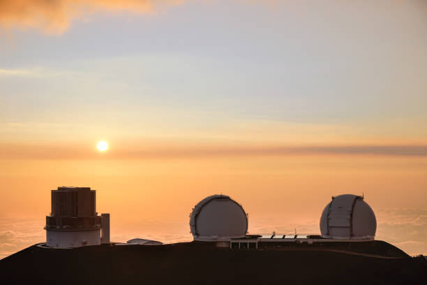 Orange sunset and the Observatory on Mauna Kea covered in best sunset light.