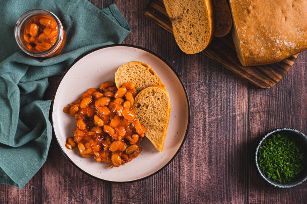 istock Baked beans with vegetables and rye bread on a plate on the table top view 2158004482