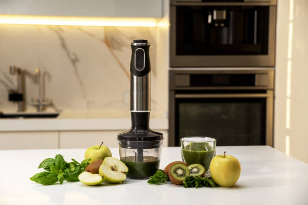 istock Electric immersion blender on kitchen table with green vegetables 2158006900