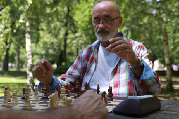 istock Senior play chess in park 2158007298