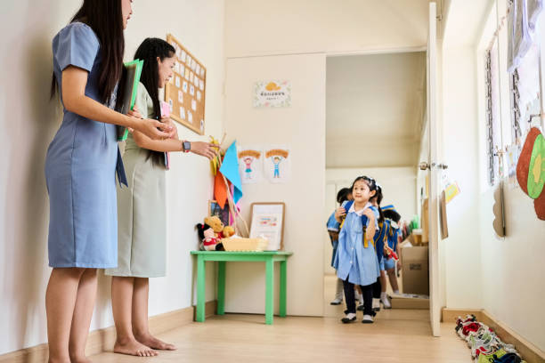 istock Two teachers assisting students leaving their classroom at kindergarten 2158008348