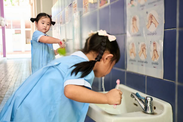 istock Young children brushing their teeth in sink at preschool 2158008405