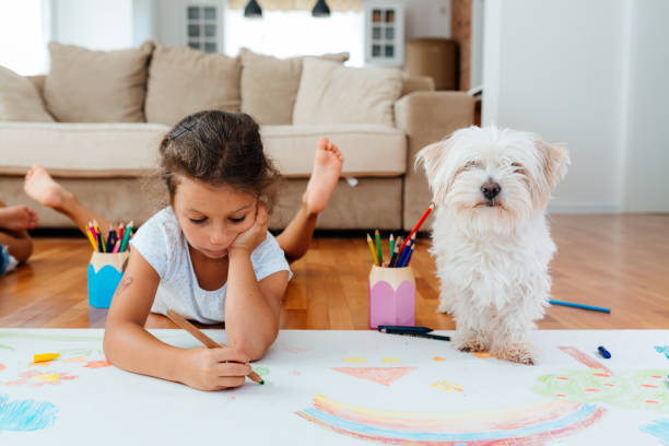 istock Little girl drawing together with her dog 2158009302