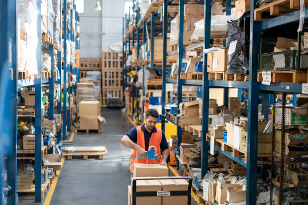 istock Man warehouse worker sealing a box with adhesive tape for delivery 2158009595
