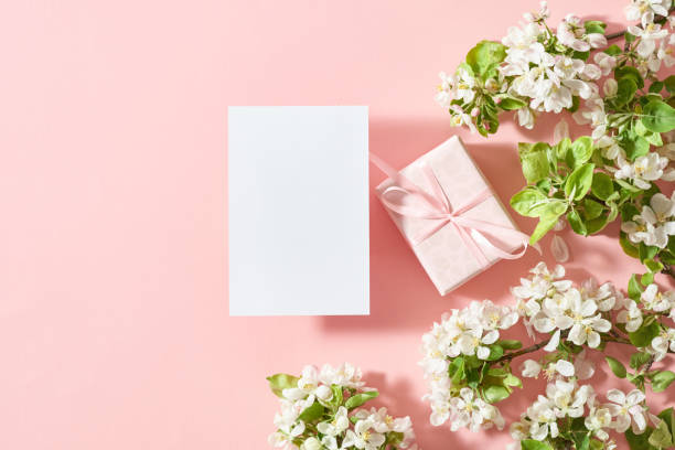 istock Mockup invitation or blank greeting card and gift box with spring flowers on a pink background 2158011095