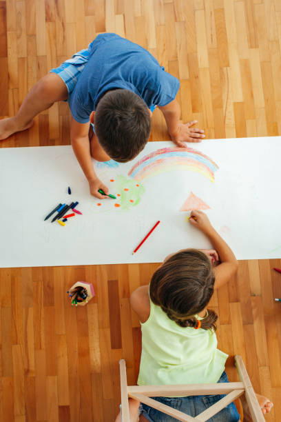 istock Children lying on the floor and drawing with crayons on a paper 2158011597