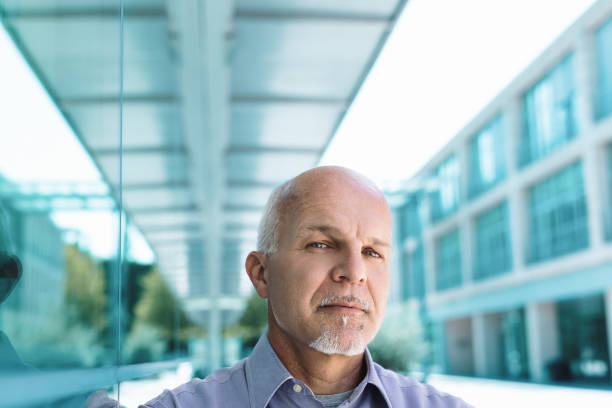 istock Serious businessman with goatee thinking about future in front o 2158012379