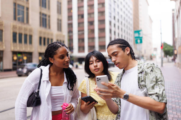 Students looking at a smartphone while walking down the street in the modern city