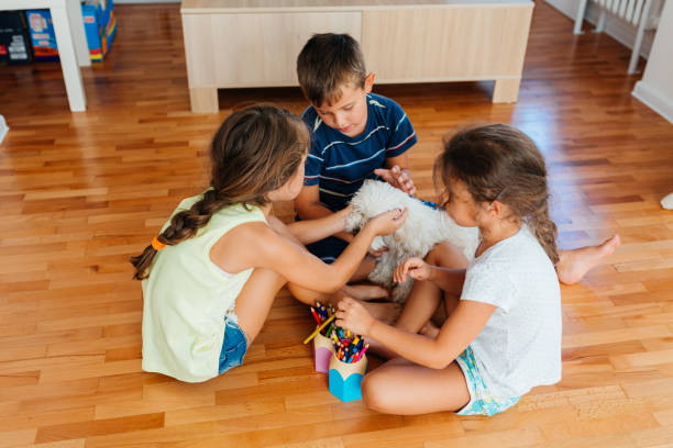 istock Children enjoys playing and cuddle their dog at home 2158013180