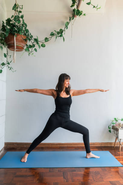 istock A Latin woman practicing yoga at home. 2158014611
