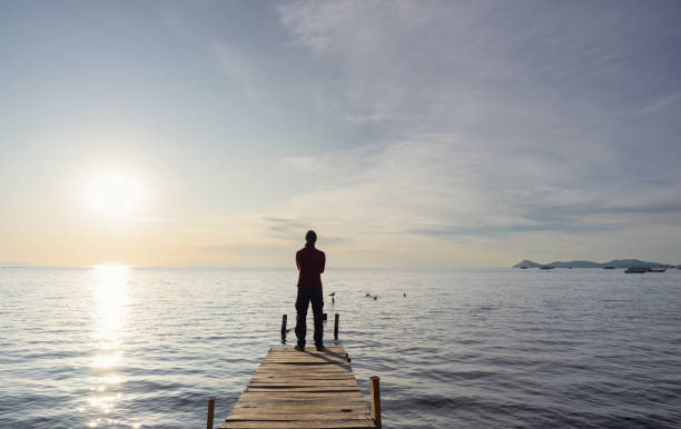 istock silhouette of a man looking at a sunset on a lake 2158016225