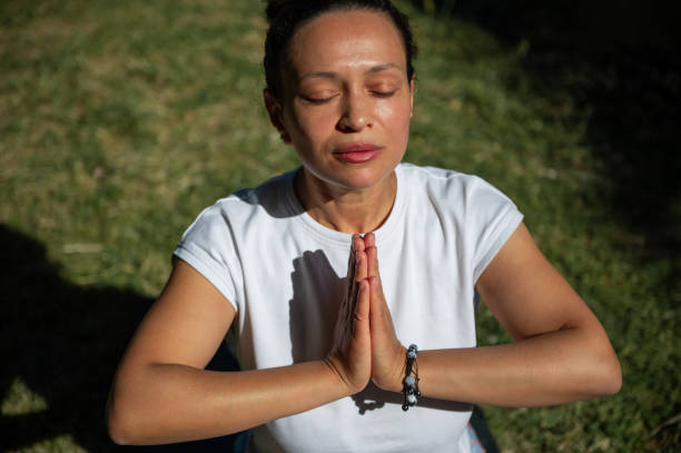 istock Woman practicing yoga meditation outdoors with eyes closed 2158018198