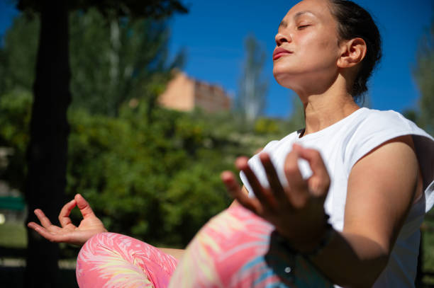 istock Woman meditating outdoors in a park, practicing mindfulness and relaxation 2158018265