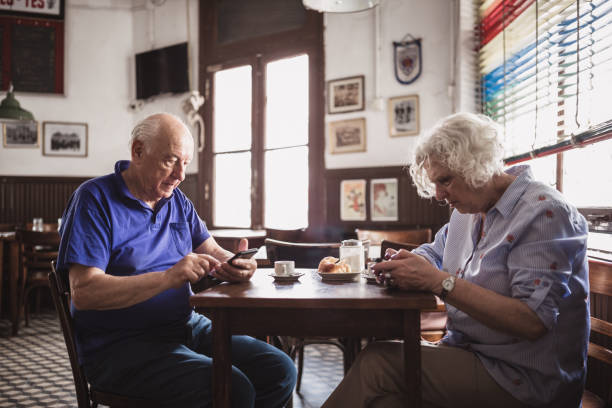 istock Elderly Couple Using Mobile Phones in Cafe 2158019650