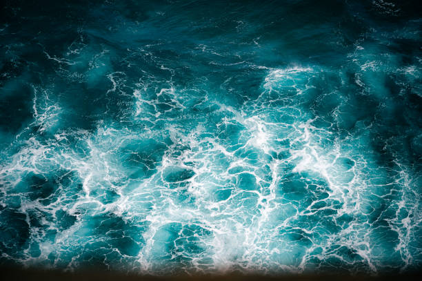 View from above of clear seawater,  ocean waves against the coast