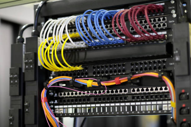 network data rack with networking equipment Network data rack with mounted networking equipment closeup. Patch cords and patch panels. Selective focus. computer cable stock pictures, royalty-free photos & images