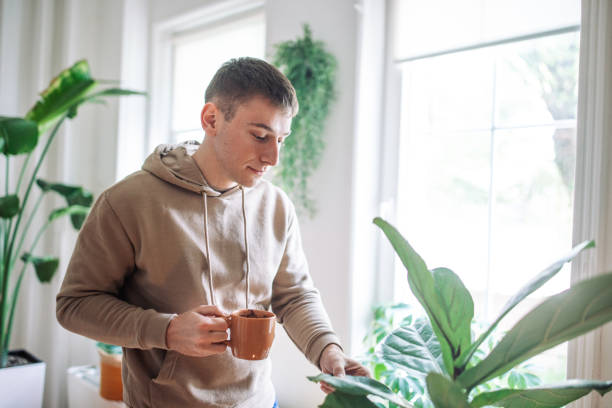 istock Morning Serenity: A Young Man’s Tranquil Moment with Nature and Coffee at Home 2158026066