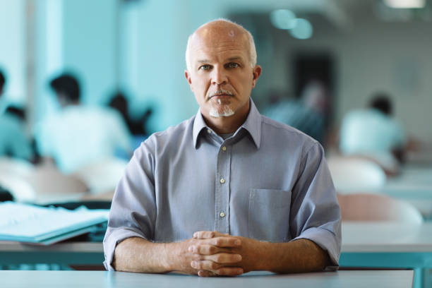 Man with white goatee, seated, professional background