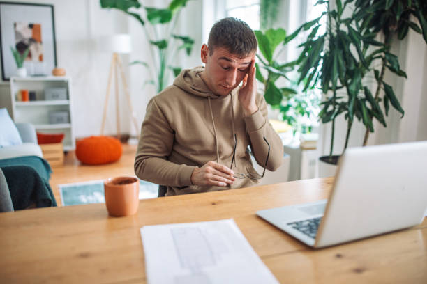 istock Exhaustion in the Digital Age: A Young Man Overwhelmed by Online Work 2158027124