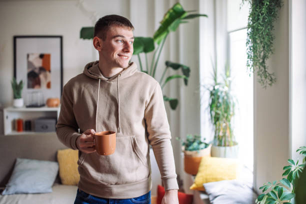 istock Morning Serenity: A Young Man’s Tranquil Moment with Nature and Coffee at Home 2158028433