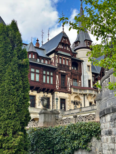Peles Castle, Sinaia, Romania - May 4, 2024 - Exterior view in the late spring of King Carol's Peles Castle, nestled in the Carpathian Mountains, near Sinaia, on an existing medieval route linking Transylvania and Wallachia. Its architectural style is a romantically inspired blend of Neo-Renaissance and Gothic Revival.