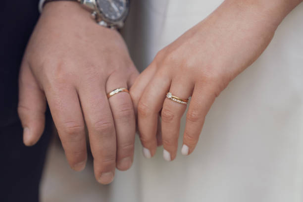 istock Married couple holding hands with rings ceremony wedding day 2158034413