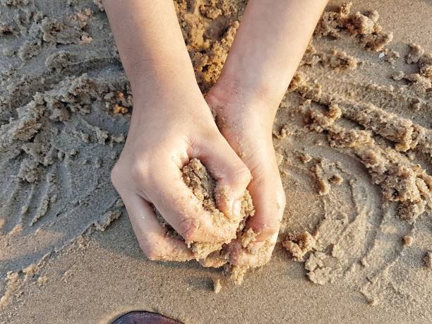 istock Hand holding sand on the beach 2158034753