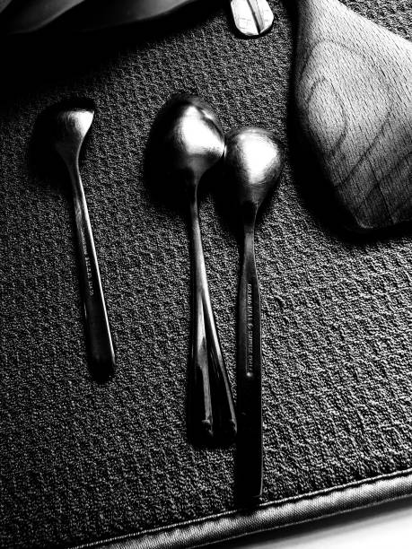 Metal and wooden spoons drying on a kitchen sink