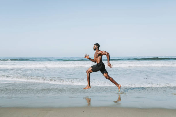 istock Fit man running at the beach 2158038391