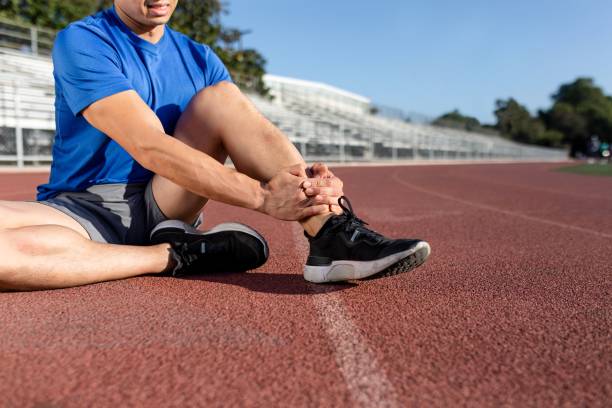 istock Man getting hurting his ankle and sitting on the track 2158040651