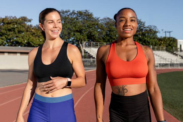 istock Two athletes laughing and talking to one another while on a running track 2158040672