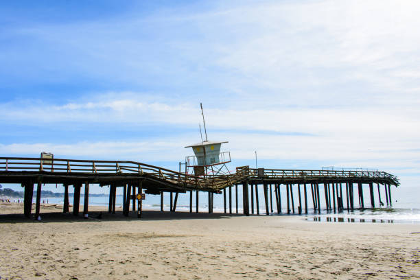 Damaged partially collapsed Seacliff Pier in California with bent railings and tilted lifeguard tower. The pier was damaged by the winter storm in 2023