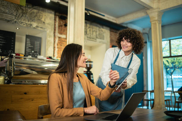 istock Businesswoman ordering a drink from the waitress 2158044136