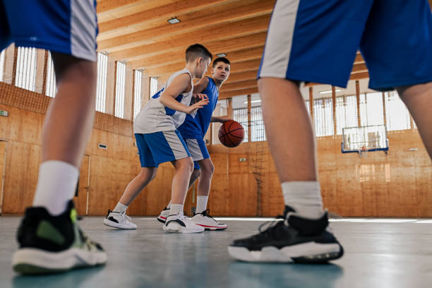 istock Kids playing basketball in a gym 2158044905