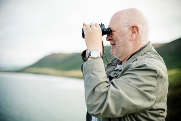 istock Happy senior man looking through a pair of binoculars 2158044926