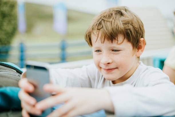 istock Happy boy playing on a mobile phone 2158045416