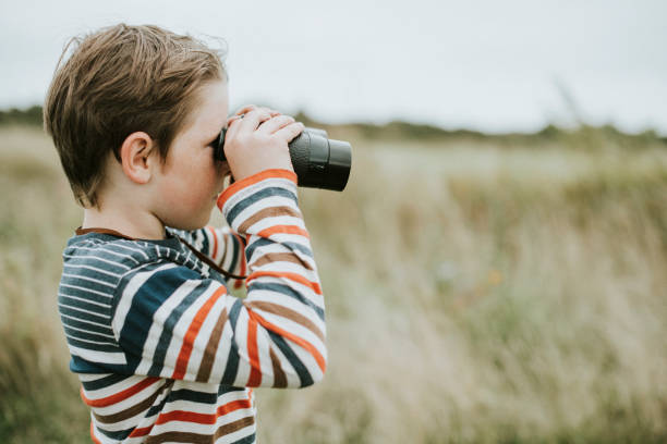 istock Young boy looking through a pair of binoculars 2158045824