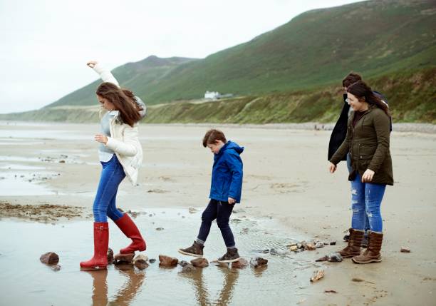 istock Kids walking on stones at the beach 2158046024