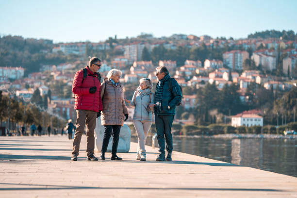 istock Caucasian Senior Couples Walking and Talking by the Seaside 2158046711