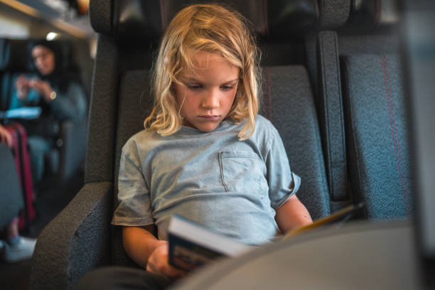 istock Caucasian Boy Enjoying a Book on the Train 2158047644