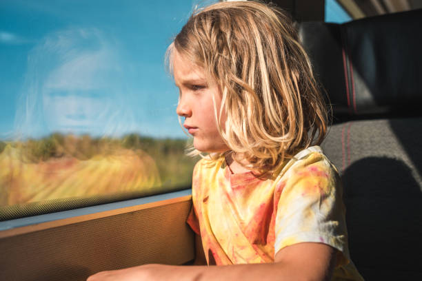 istock Boy with Blond Hair Looking at Train Window Scenery 2158047672