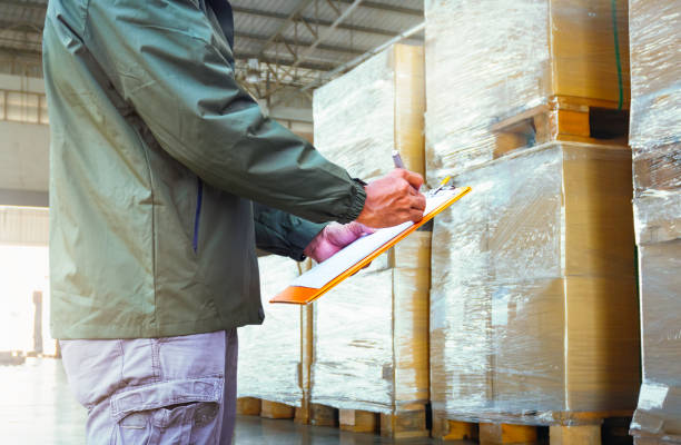 istock Warehouse worker holds a clipboard and checks a package boxes pallets. Storage warehouse. Inventory management supplies. supply chain. shipment goods Warehouse shipping logistics. 2158049517