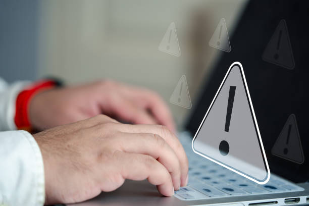 istock Businessman working on laptop computer, exclamation mark, alarm, warning, computer virus detected. 2158049807