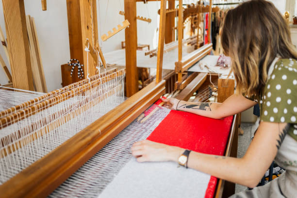 istock Woman weaving on a loom 2158050104